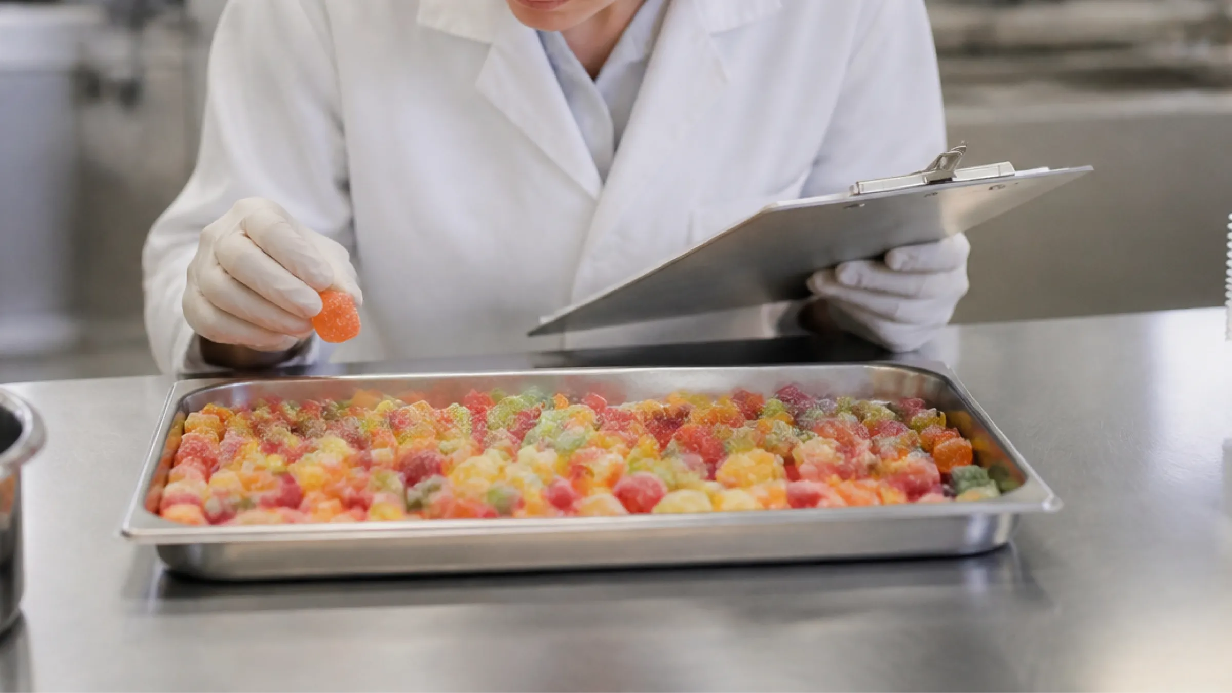 Quality control staff inspecting gummy candy samples at the Sweeto Sweets factory