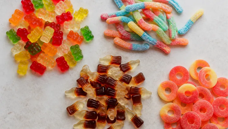Best gummy candy types arranged together: gummy bears, sour worms, cola bottles and fruit gummies