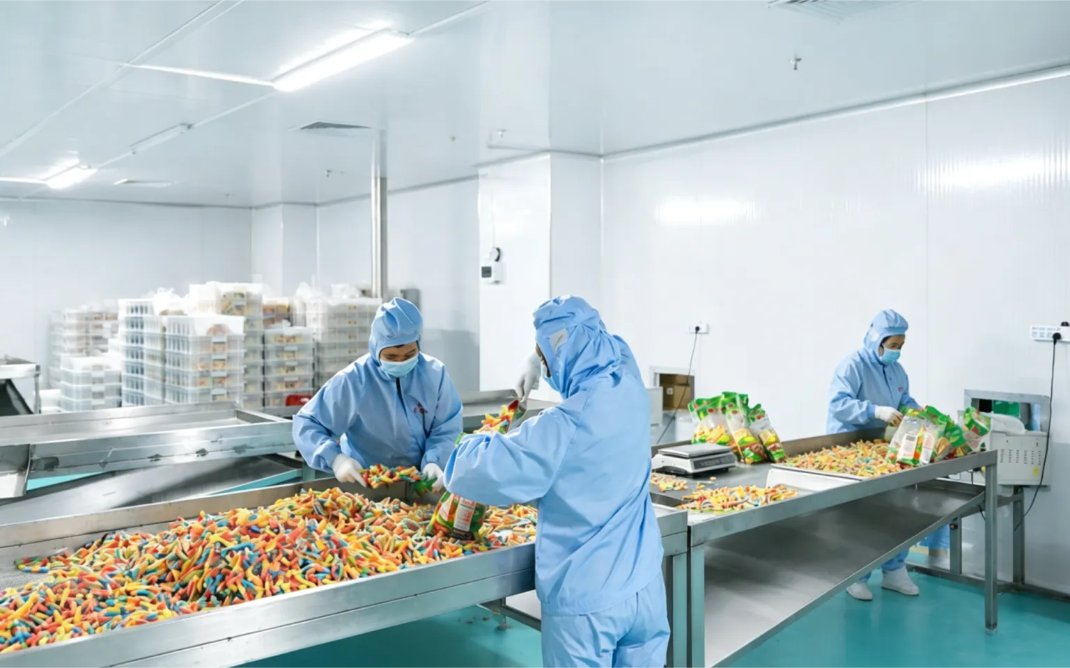 Sweeto production team sorting colorful gummies on the packing line