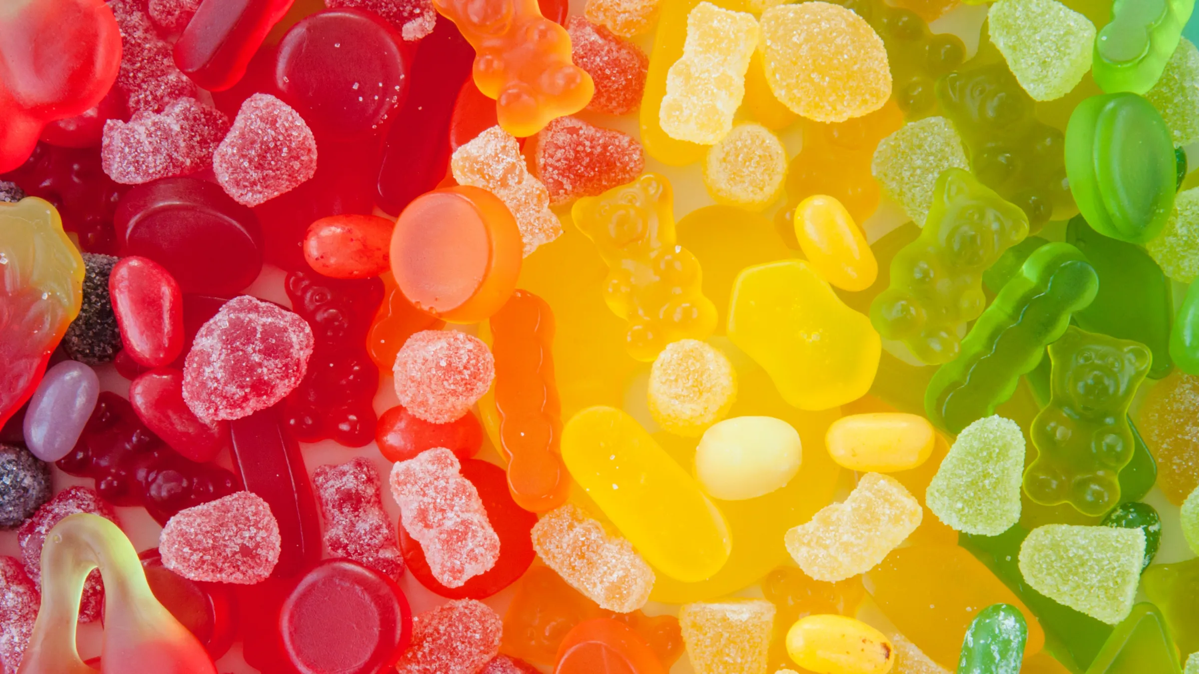 3.Rows of crystal-coated gummy candies in fruit, animal and letter shapes in different colours